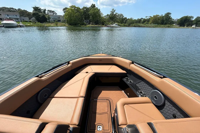 Slide: The Image of 2026 Cobalt R8 Surf boat interior with tan seating, on a serene lake. - 37