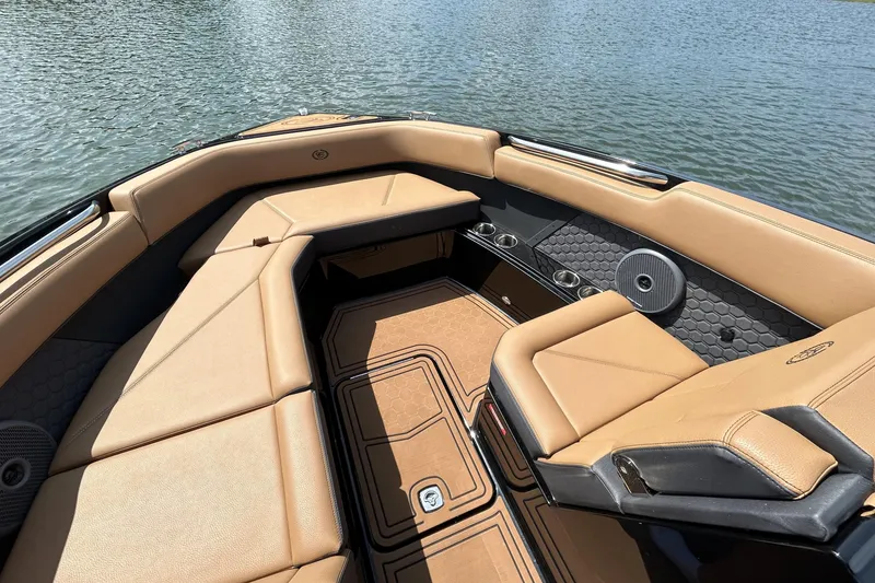 Slide: The Image of 2026 Cobalt R8 Surf boat interior with tan seating and cup holders on a calm lake. - 38