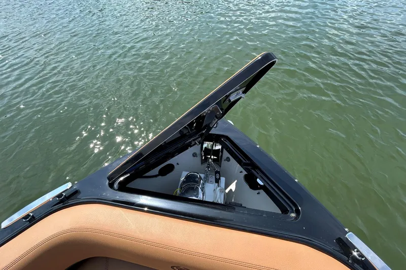 Slide: The Image of 2026 Cobalt R8 Surf boat with open storage compartment on calm water. - 41