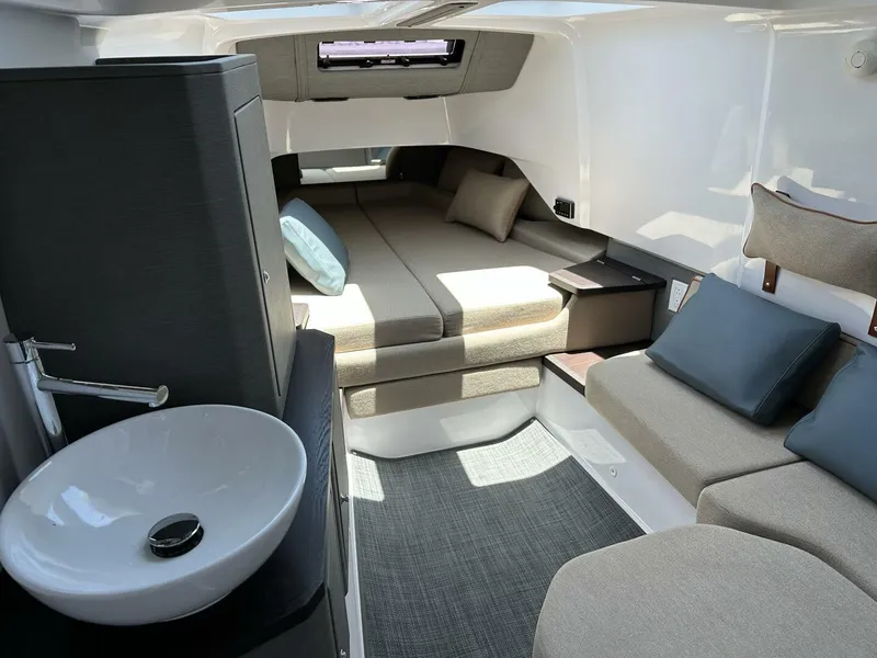 Slide: The Image of 2022 Axopar 37 XC CROSS CABIN interior with cozy seating and modern sink. - 13