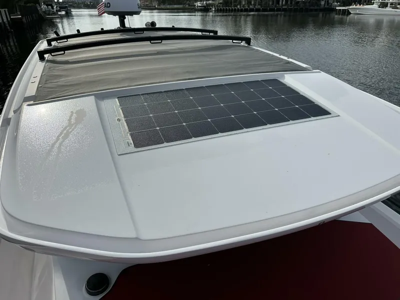 Slide: The Image of 2022 Axopar 37 XC CROSS CABIN with solar panel on deck, docked by the water. - 17