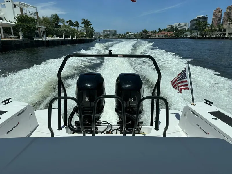 Slide: The Image of 2022 Axopar 37 XC CROSS CABIN cruising on a scenic waterway with dual engines. - 4