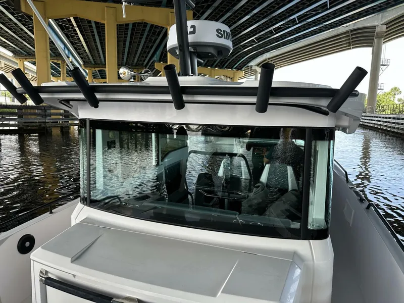 Slide: The Image of 2022 Axopar 37 XC CROSS CABIN boat under a bridge, showcasing its sleek design. - 7