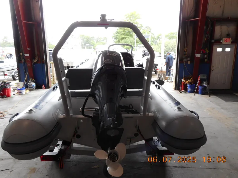 Slide: The Image of 2025 Highfield Classic 420 boat in a garage, rear view with motor and trailer. - 4