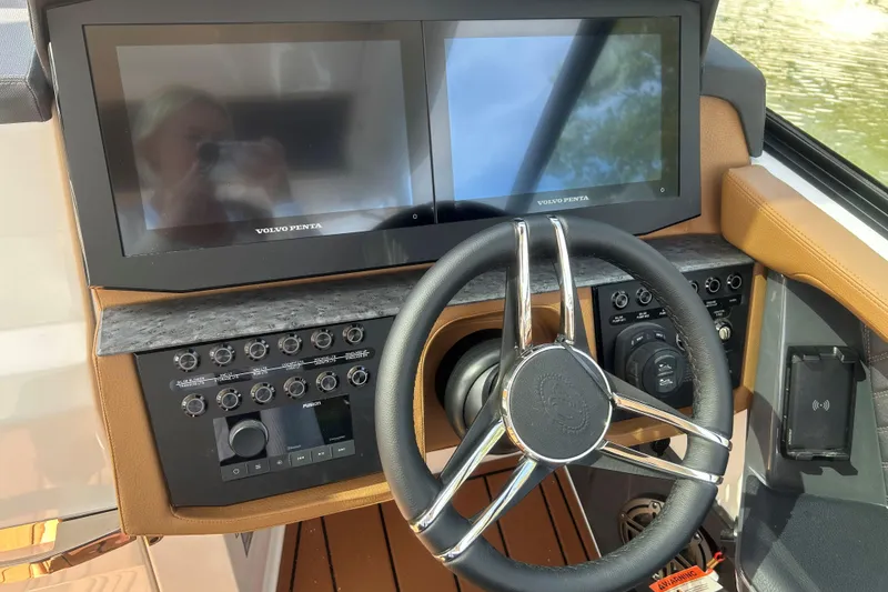 Slide: The Image of 2026 Cobalt R31 boat with luxurious tan seating on a calm lake. - 16