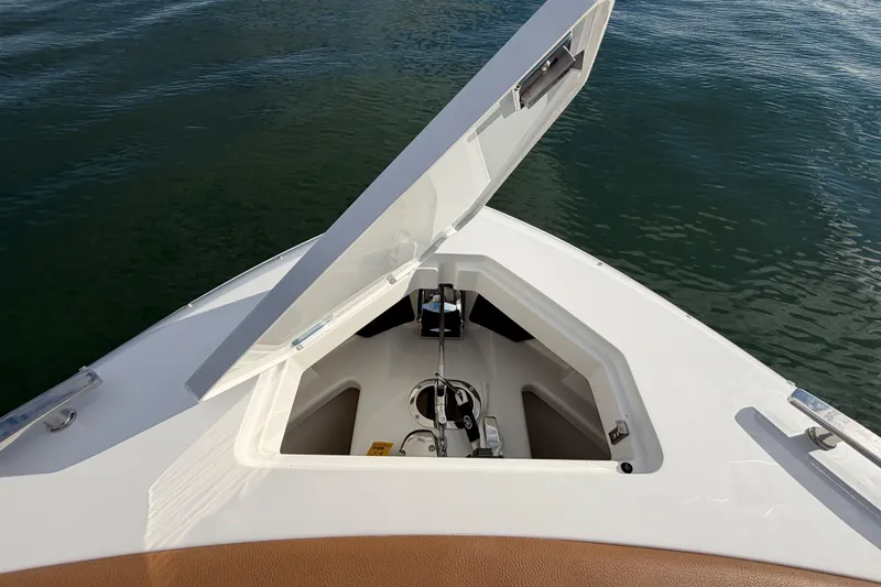 Slide: The Image of Open anchor compartment on 2026 Cobalt R31 boat, floating on calm water. - 33