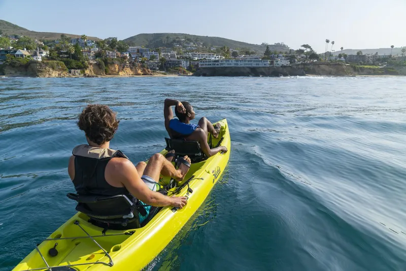 Slide: The Image of Two people kayaking in a 2024 Hobie Oasis on a sunny coastal day. - 4