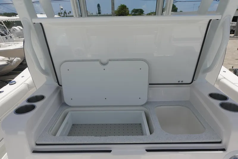 Slide: The Image of 2025 Sea Fox 328 Commander boat storage compartment with open lid and cup holders. - 16