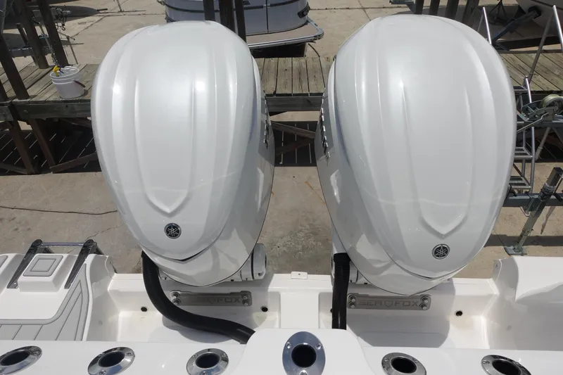 Slide: The Image of Twin outboard engines on a 2025 Sea Fox 328 Commander boat, docked at a marina. - 33