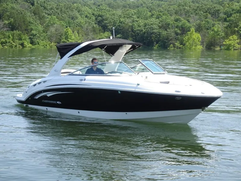 The Image of 2014 Chaparral 287 SSX boat cruising on a serene lake with lush greenery. - 0
