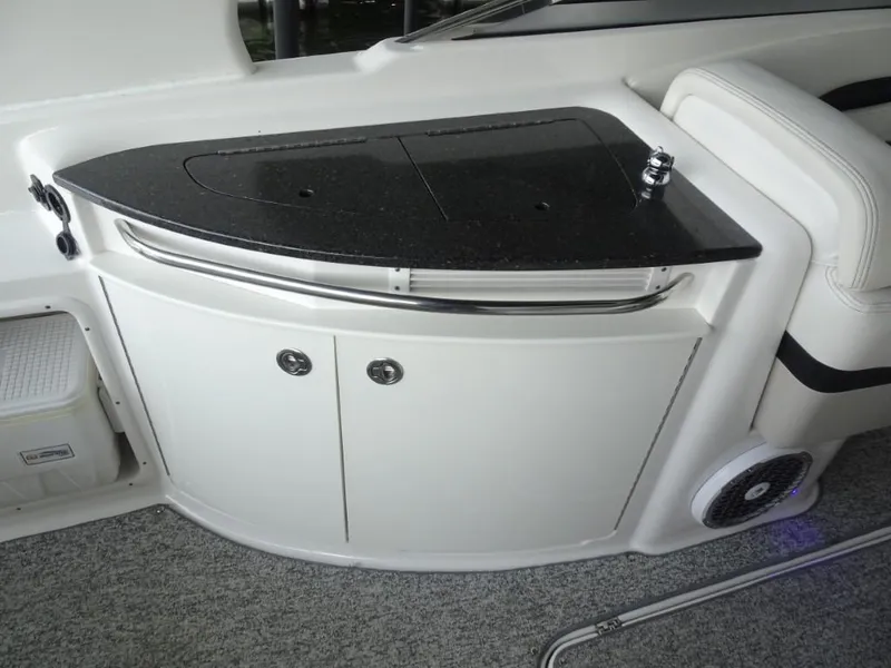 Slide: The Image of 2014 Chaparral 287 SSX boat interior with sleek black countertop and storage cabinets. - 12