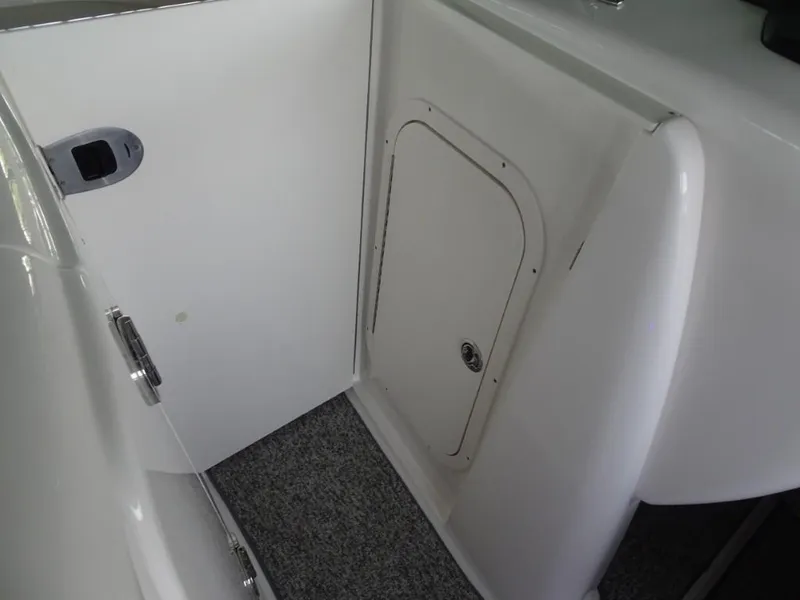 Slide: The Image of 2014 Chaparral 287 SSX boat interior with storage compartment and carpeted floor. - 21