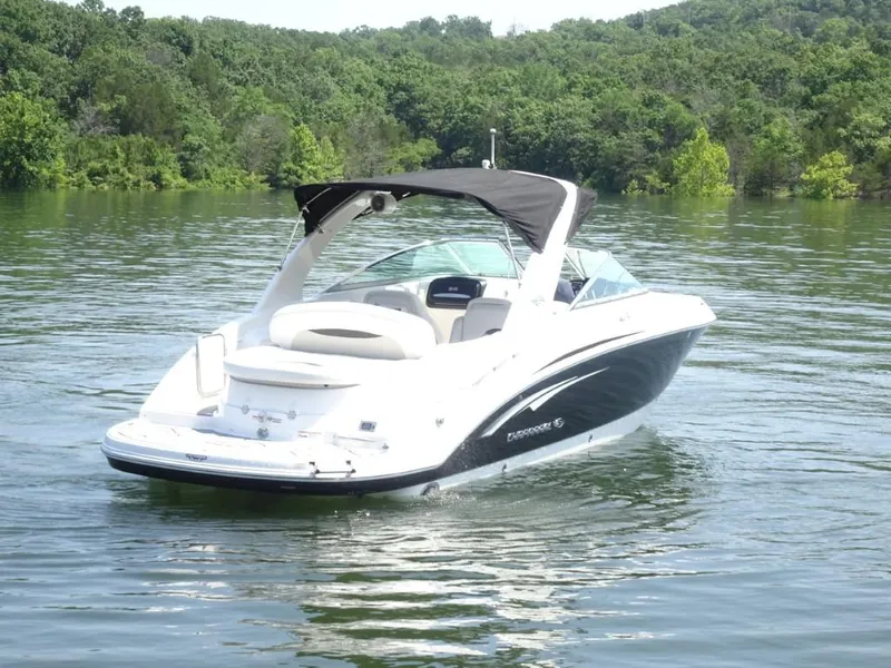 Slide: The Image of 2014 Chaparral 287 SSX boat on a serene lake with lush green background. - 3