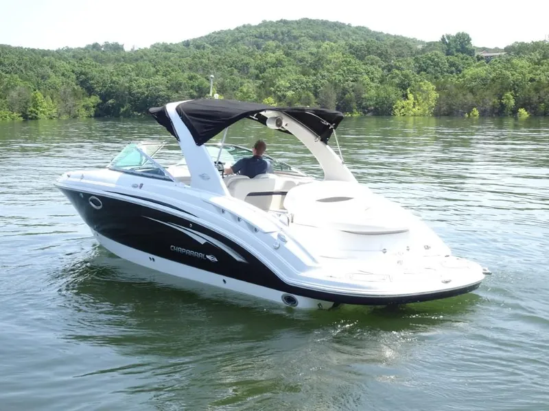 Slide: The Image of 2014 Chaparral 287 SSX boat cruising on a lake with lush green hills in the background. - 5