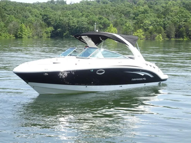 Slide: The Image of 2014 Chaparral 287 SSX boat on a calm lake with lush green forest backdrop. - 8