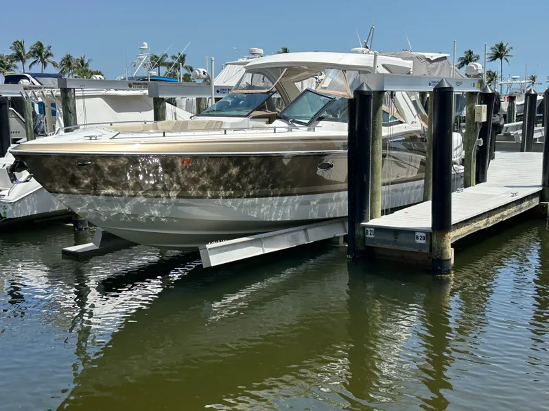 The Image of 2019 Formula 350 Crossover Bowrider docked at marina, reflecting on calm water. - 0