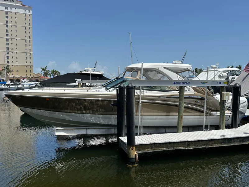 Slide: The Image of 2019 Formula 350 Crossover Bowrider docked at marina under clear blue sky. - 1