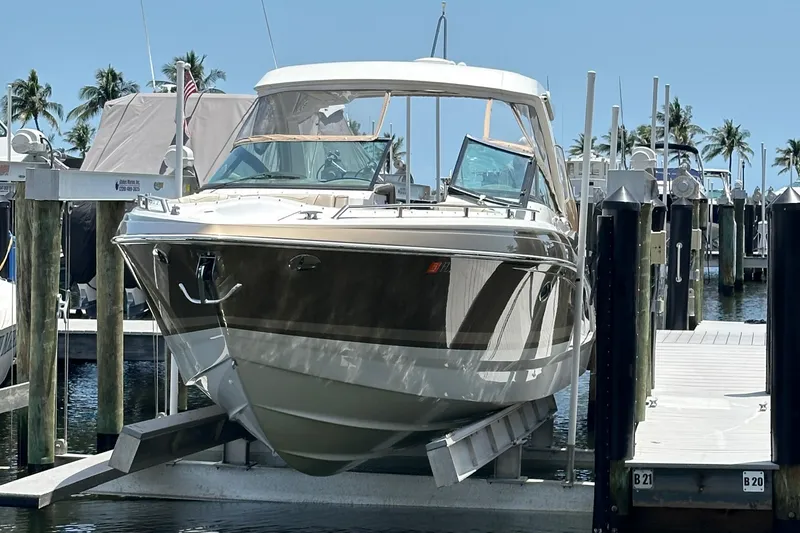 Slide: The Image of 2019 Formula 350 Crossover Bowrider docked at marina with palm trees in background. - 2