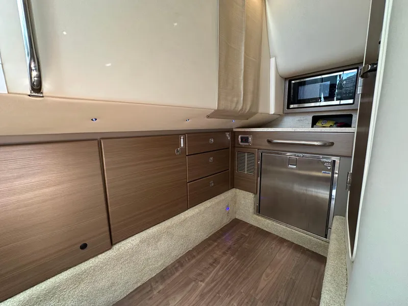 Slide: The Image of 2019 Formula 350 Crossover Bowrider cabin interior with wood cabinetry and stainless steel appliances. - 24