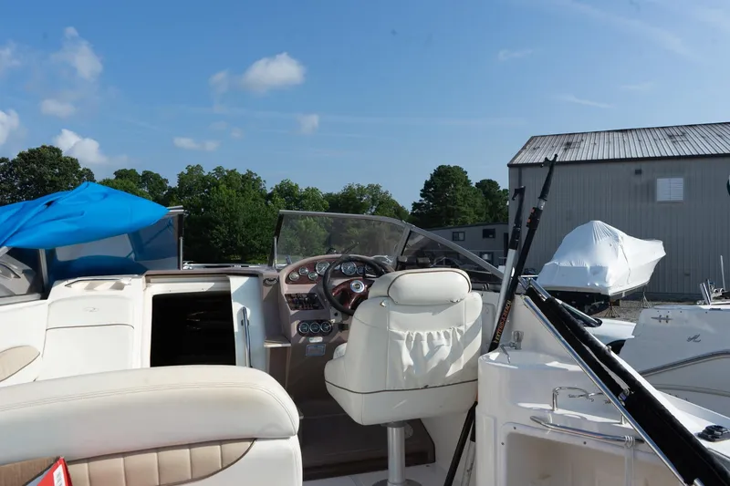 Slide: The Image of 2004 Regal Commodore 2765 boat interior with steering wheel and seating, docked outdoors. - 17