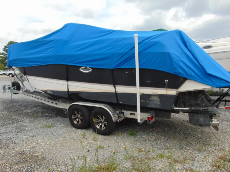 Slide: The Image of 2004 Regal 2765 Commodore boat covered with blue tarp on trailer. - 2