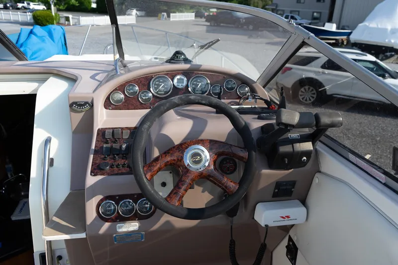 Slide: The Image of 2004 Regal Commodore 2765 boat dashboard with steering wheel and control panel. - 21