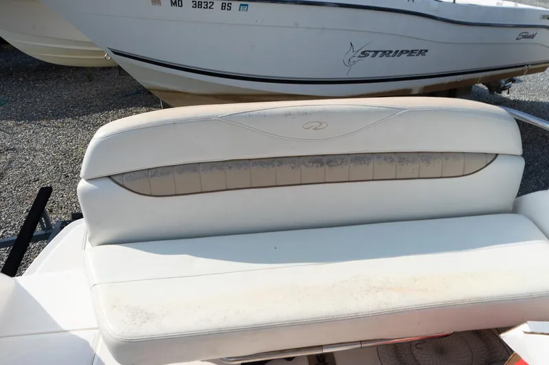 Slide: The Image of 2004 Regal Commodore 2765 boat seat with visible wear, parked near another boat. - 27