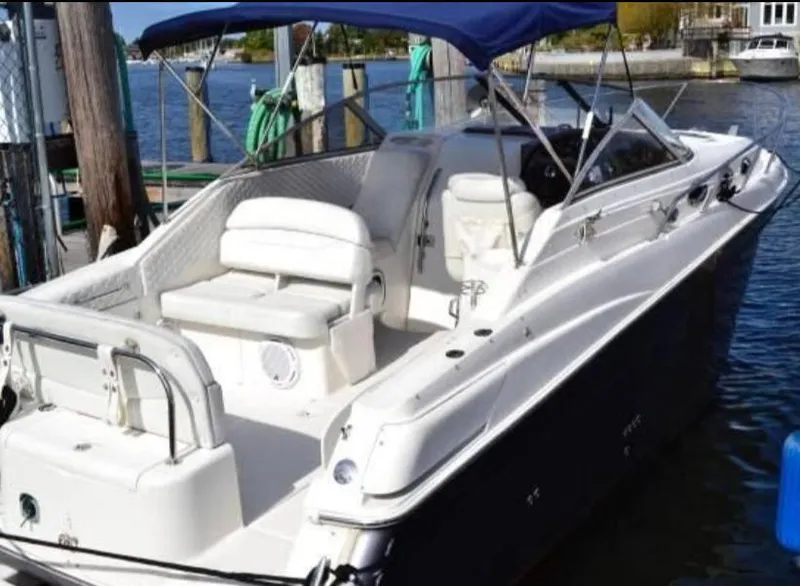 Slide: The Image of 2004 Regal Commodore 2765 boat docked, featuring spacious seating and a blue canopy. - 7