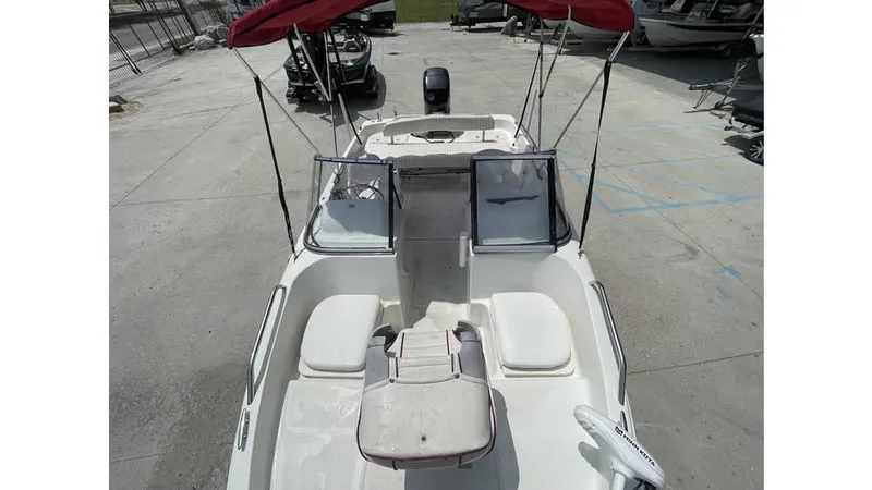 Slide: The Image of 2002 Bay Stealth 1880 boat with red canopy, viewed from above, in a marina setting. - 12