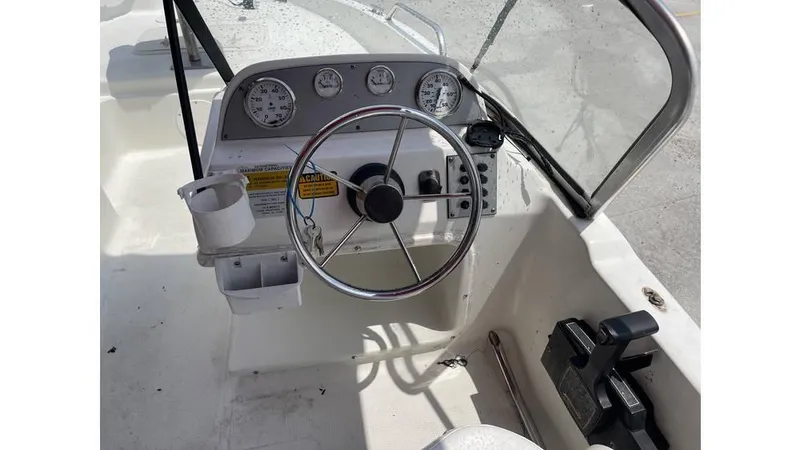 Slide: The Image of 2002 Bay Stealth 1880 boat dashboard with steering wheel and gauges. - 15