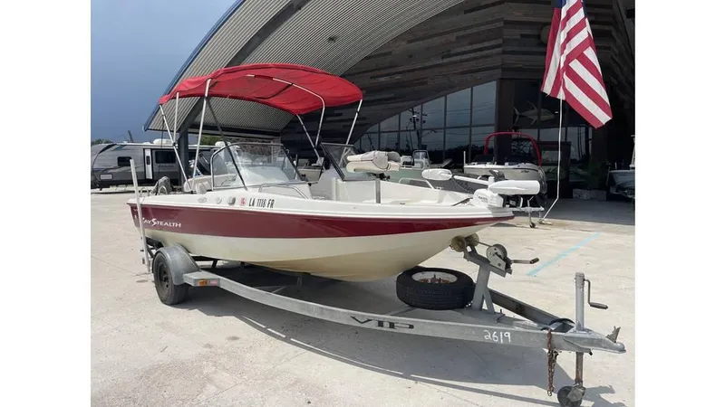 Slide: The Image of 2002 Bay Stealth 1880 boat on trailer with red canopy and American flag. - 8