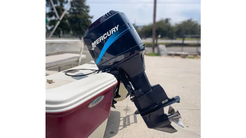 Slide: The Image of 2002 Bay Stealth 1880 boat with Mercury outboard motor, docked outdoors. - 9
