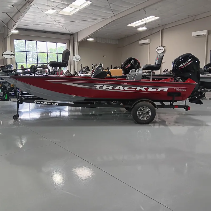 The Image of 2025 Tracker Pro Team 175 boat in showroom, red and silver design, on trailer. - 0