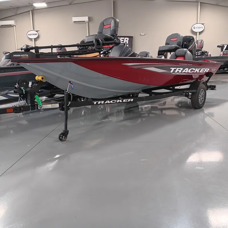 Slide: The Image of 2025 Tracker Pro Team 175 boat in showroom, red and gray design, on trailer. - 2