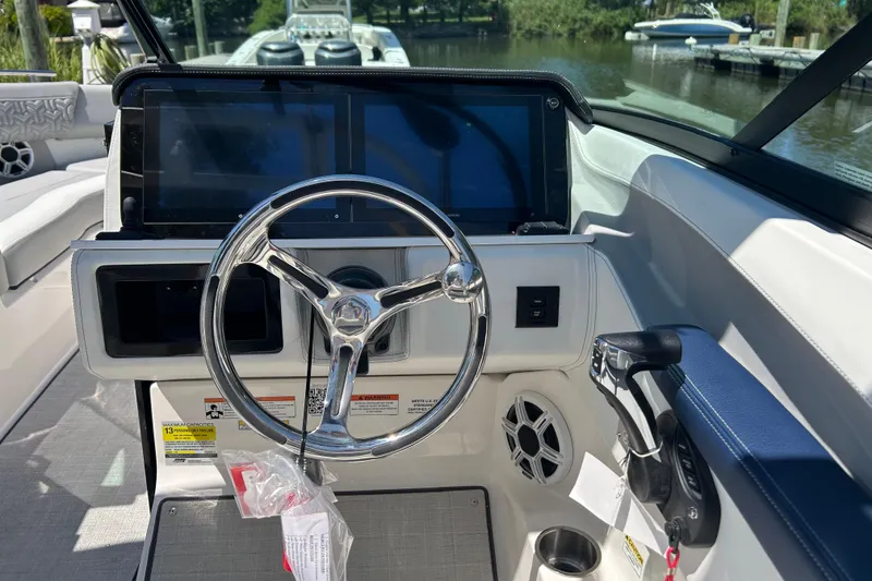 Slide: The Image of 2026 Regal LX4 boat cockpit with steering wheel, dual screens, and control panel. - 13