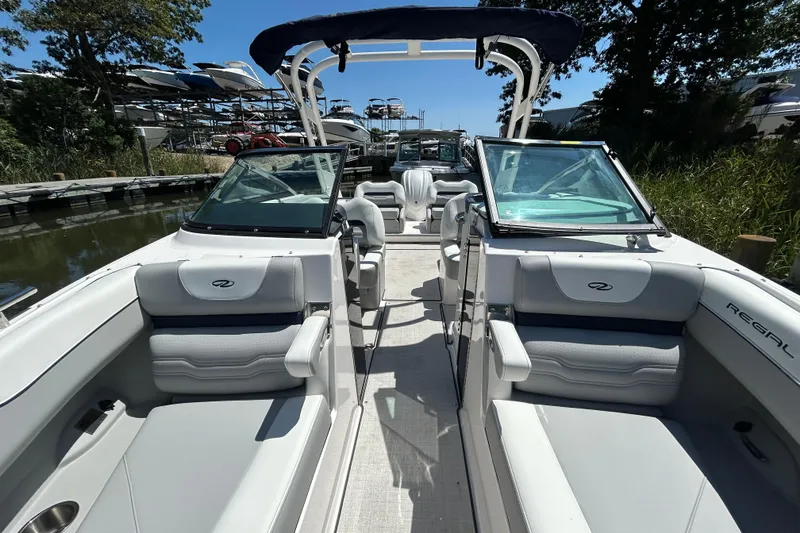 Slide: The Image of 2026 Regal LX4 boat interior with luxurious seating and sleek design at a marina. - 17