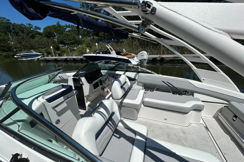 Slide: The Image of 2026 Regal LX4 boat interior with white seating, sleek design, docked by a serene waterway. - 18