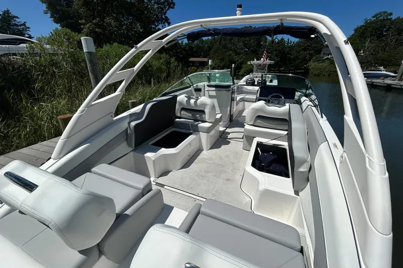 Slide: The Image of 2026 Regal LX4 boat interior with sleek seating and modern design, docked by lush greenery. - 7