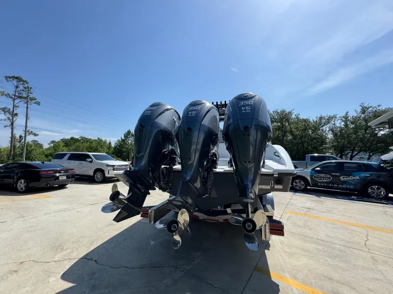 Slide: The Image of 2026 Yellowfin 36 Offshore boat with triple outboard engines in a parking lot. - 12