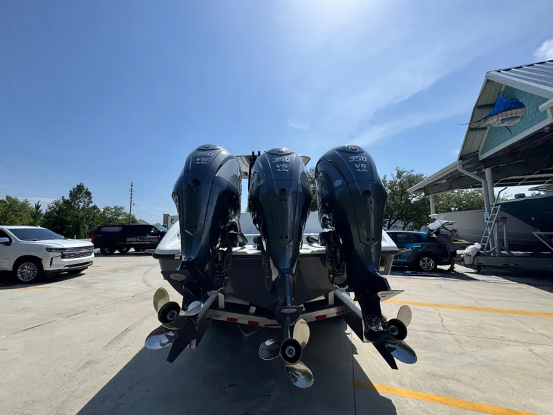 Slide: The Image of 2026 Yellowfin 36 Offshore boat with triple outboard engines in a sunny marina. - 13