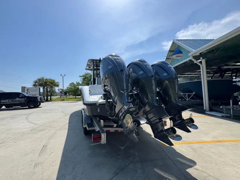 Slide: The Image of 2026 Yellowfin 36 Offshore boat with triple outboard engines in a sunny marina. - 14