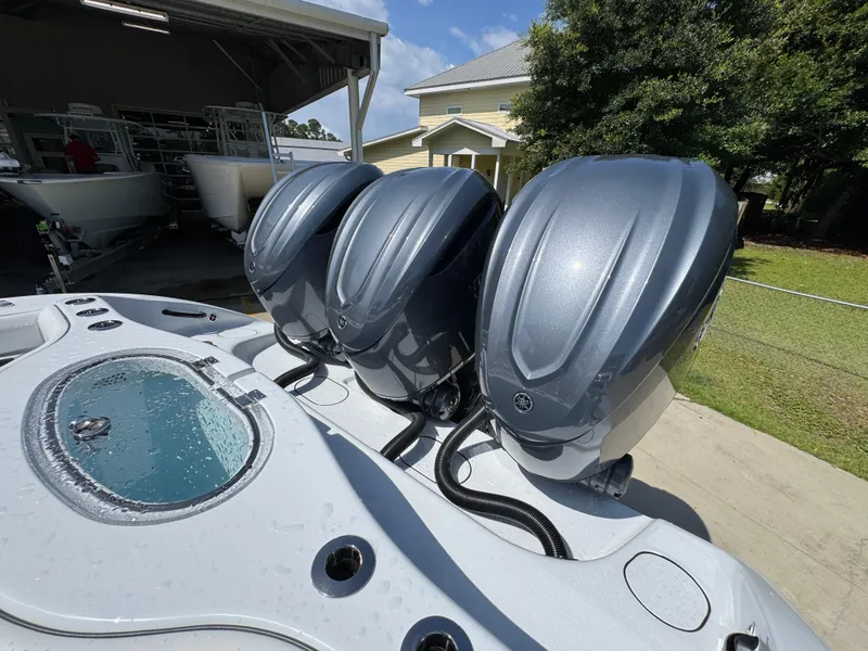 Slide: The Image of Triple outboard engines on a 2026 Yellowfin 36 Offshore boat, parked outdoors. - 38
