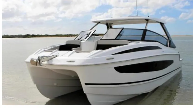 Slide: The Image of Aquila 32 Sport 2022 boat on calm water under a partly cloudy sky. - 2
