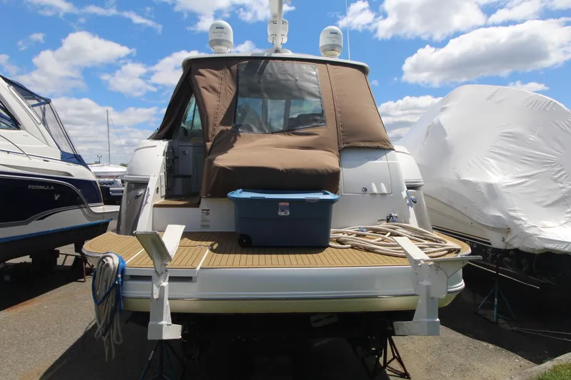 Slide: The Image of 2013 Cruisers Yachts 430 SC docked, featuring a covered deck and storage container. - 2