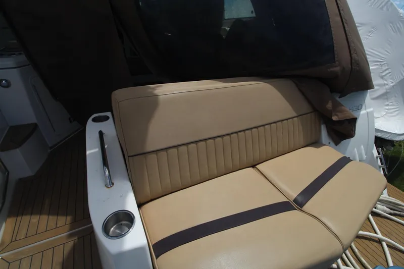Slide: The Image of 2013 Cruisers Yachts 430 SC interior seating with beige upholstery and cup holder. - 35