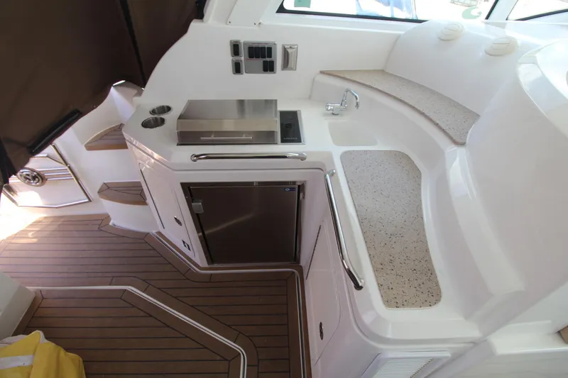 Slide: The Image of 2013 Cruisers Yachts 430 SC interior with kitchenette, sink, and wooden flooring. - 7