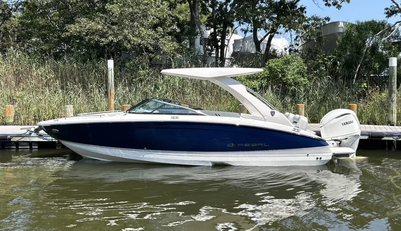 The Image of 2026 Regal LX6 boat docked on calm water, featuring sleek design and Yamaha engine. - 0