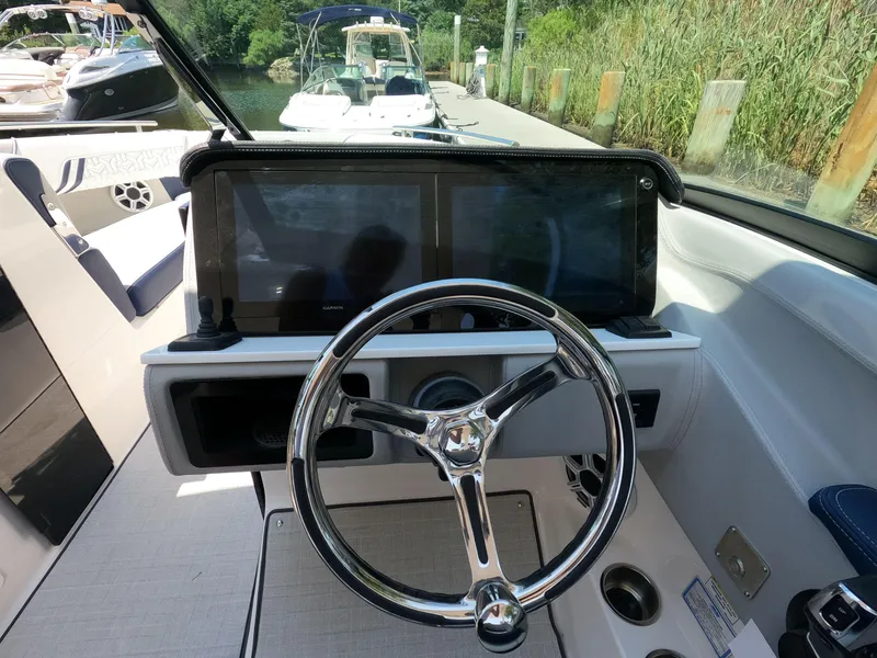 Slide: The Image of 2026 Regal LX6 boat dashboard with steering wheel and dual displays. - 13