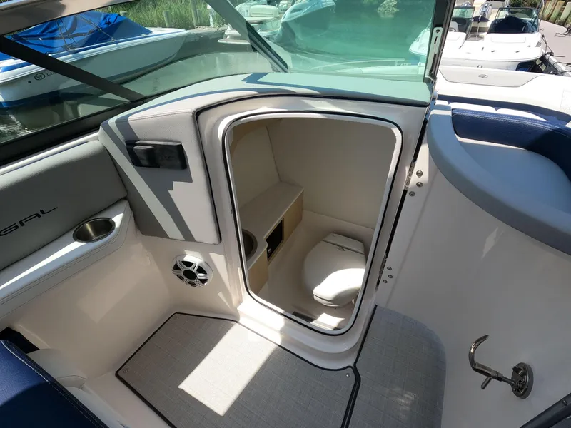 Slide: The Image of 2026 Regal LX6 boat interior with open door to compact bathroom. - 16