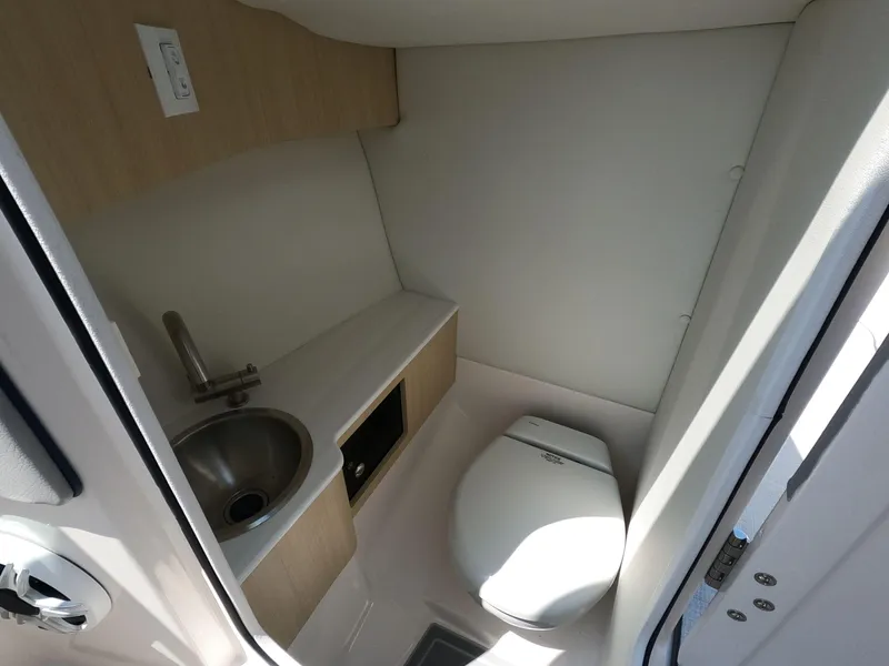 Slide: The Image of 2026 Regal LX6 boat interior with compact bathroom, featuring a sink and toilet. - 17